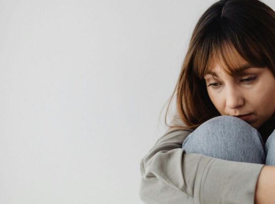 Γυναίκα κάθεται στο πάτωμα σκεπτική - Αφιέρωμα για αυτοάνοσα νοσήματα, Χασιμότο και αγκυλοποιητική σπονδυλαρθρίτιδα