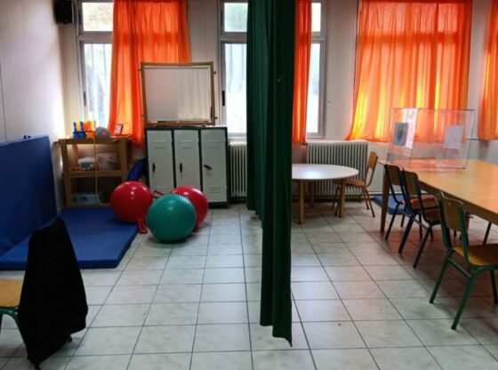 Αίθουσα θεραπειών και διδασκαλίας στα Ειδικά Σχολεία Λευκάδας, η οποία διαχωρίζεται πρόχειρα με μια πράσινη υφασμάτινη κουρτίνα.